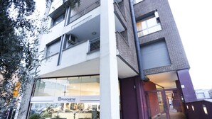 Un edificio de varios pisos con una planta baja comercial que alberga una tienda Husqvarna.