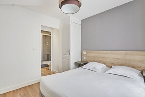 Un dormitorio con una cama grande, cabecera de madera, una mesita de noche y un armario.