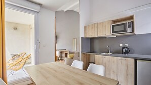 Eine moderne Küche mit Holzschränken, einer eingebauten Mikrowelle und einem Spülbecken.