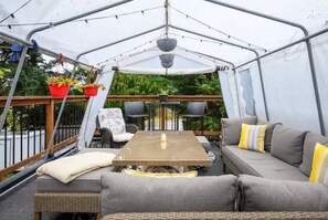 A covered patio area with a table, chairs, and a sofa. - Nature’s nook near city (Victoria)