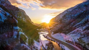 Un paisaje nevado con un río y una carretera.