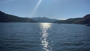 Un lago tranquilo con barcos, rodeado de colinas.