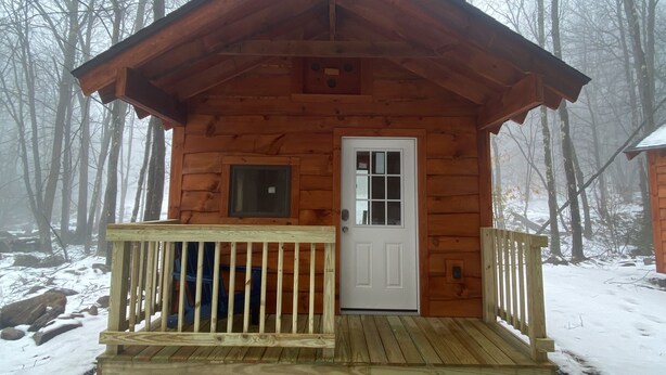 A wooden cabin with a porch, a door, and a window. - Taborton Harvest
Boulder Pines
Cabin in the woods (Sand Lake)