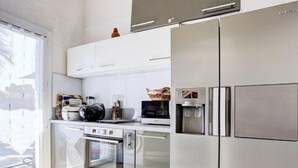 Eine moderne Küche mit Edelstahlgeräten, einem Backofen und einem Wasserspender.
