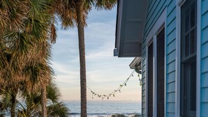 A wooden deck with a picnic table and chairs, overlooking the ocean. - Oceanfront Family Retreat + Private Beach Access (Folly Beach)