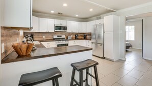 A modern kitchen with white cabinets, a wooden countertop, a stainless steel refrigerator, and a wooden bowl on the counter. - 5 Mi to Dtwn: Pet-Friendly Phoenix Gem w/ Patio (Phoenix)
