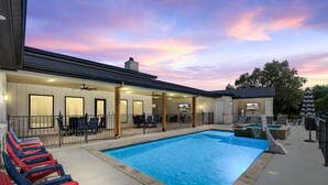 A swimming pool with lounge chairs, a covered seating area, and a view of the sunset. - Hot tub, pool, Sonos speaker system (Concan)