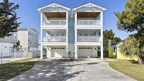 A two-story residential building with a central entrance, a covered porch, and a garage.