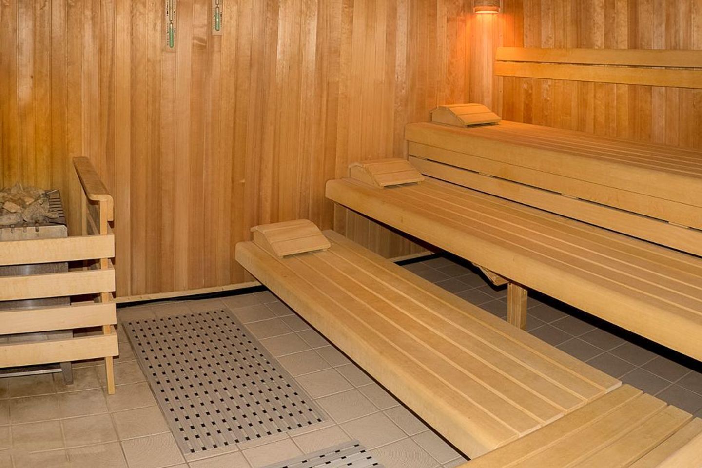 Sauna, jossa on puiset lauteet ja laatoitettu lattia.