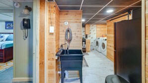A compact, wood-paneled room with a sink, a washing machine, and a refrigerator. - Beckley Studio w/ Private Hot Tub & Home Gym! (Beckley)