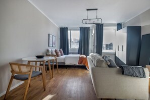 Relax in a spacious living area with a sofa, dining table, and city views.