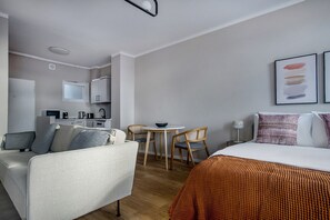 Relax in a comfortable room with a bed, sofa, and compact kitchenette.