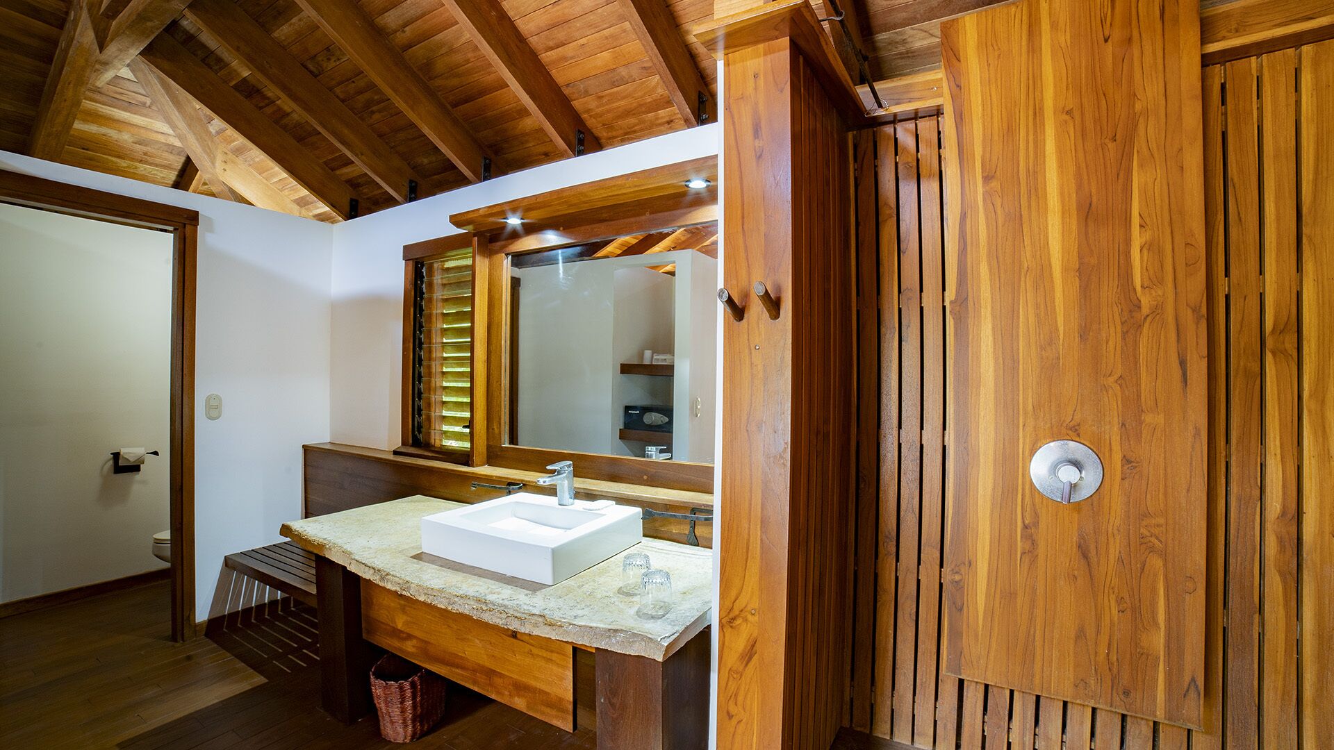 A bathroom with a wooden vanity, a sink, and a mirror.
