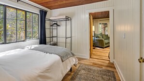 A bedroom with a bunk bed, a large window, and a view of the outdoors. - Cozy retreat, newly renovated with loft, hot tub, creek access, pet friendly (Rhododendron)