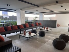 Un espace détente moderne comprenant un canapé, des tables basses et des vases décoratifs.