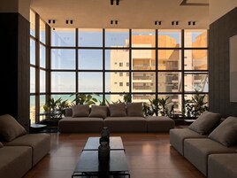 Un salon moderne avec une grande fenêtre, un canapé et une table basse.