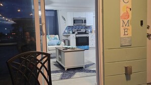 Ein modernes Wohnzimmer mit Glastür zum Küchenbereich.