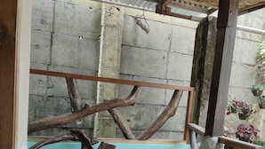 A rustic wooden table with a metal tray, a blue bathtub, and a wooden headrest. - Shenamae Pension  (San Vicente)