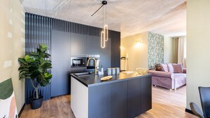 A modern kitchen with a central island, built-in appliances, and a pendant light.