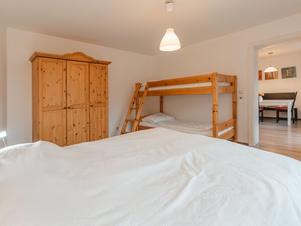 A bedroom with a bunk bed, wooden wardrobe, and a desk with a chair. - Landhaus St. Georg by Interhome (Bad Gastein)