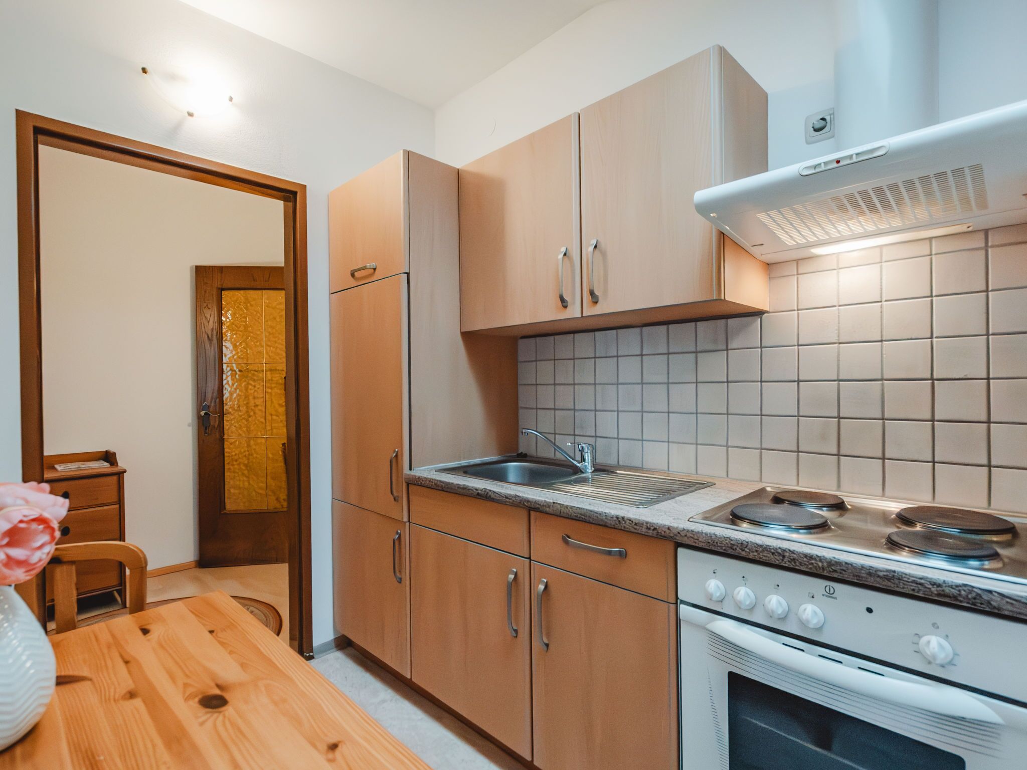 Une cuisine moderne avec des meubles en bois, un évier en acier inoxydable et un four encastré.