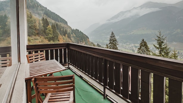 A balcony with wooden furniture and a view of a mountainous landscape. - Landhaus St. Georg by Interhome (Bad Gastein)