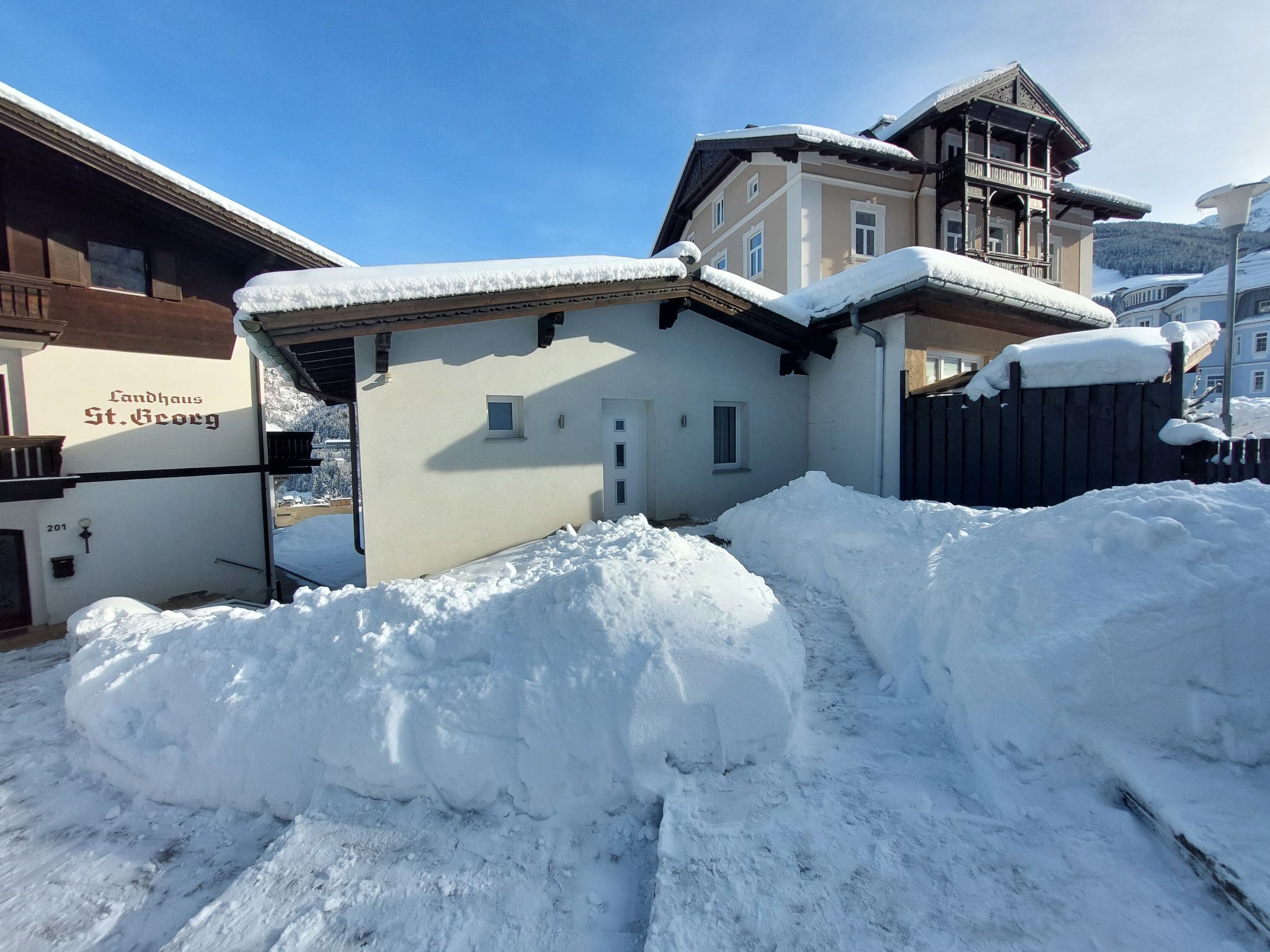 Um edifício coberto de neve com uma placa que diz "Landhaus St. Georg".