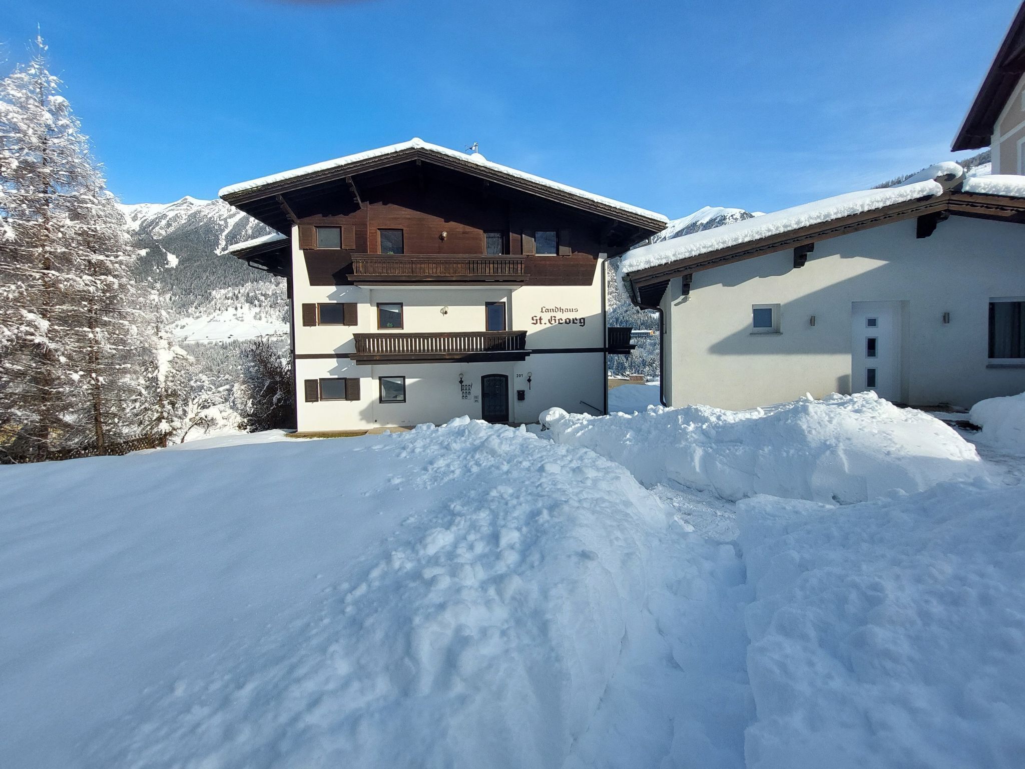 Un bâtiment à deux étages doté d’un balcon en bois et d’une enseigne indiquant « Landhaus St. Georg ».