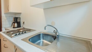 A kitchen with a stainless steel sink, double oven, and white cabinets. - Landhaus St. Georg by Interhome (Bad Gastein)