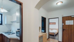 Habitación de hotel compacta con kitchenette, cama y baño.