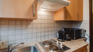 A kitchen with a stainless steel sink, two stovetops, a coffee maker, and a toaster. - Landhaus St. Georg by Interhome (Bad Gastein)