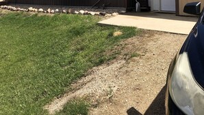 Una casa móvil de dos pisos con porche delantero, garaje y entrada para vehículos.