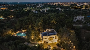 A modern house with a swimming pool surrounded by trees, located in a suburban area with other houses and greenery. - Villa Giari 8 Emma Villas (Ceglie Messapica)