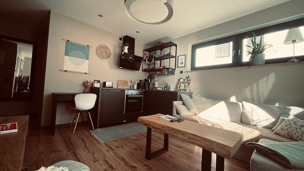 Un espacio de estar moderno con cocina, comedor y zona de descanso.