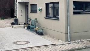 Un edificio moderno de dos pisos con techo plano, varias ventanas y una puerta visible.