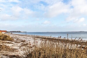 A beach with sand, seaweed, and a clear sky. - Holiday Apartment Rüde-Mühle with Private Terrace, Private Garden and Wi-Fi (Munkbrarup-Rüde)