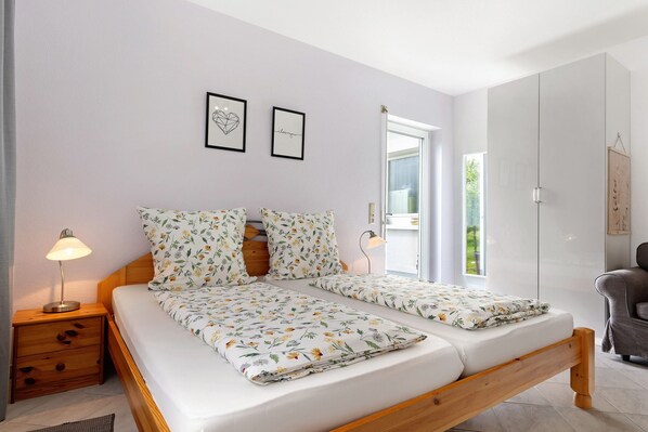 A bedroom with a bed, nightstands, a lamp, and a chair.