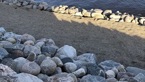 Una costa rocosa con una masa de agua tranquila.