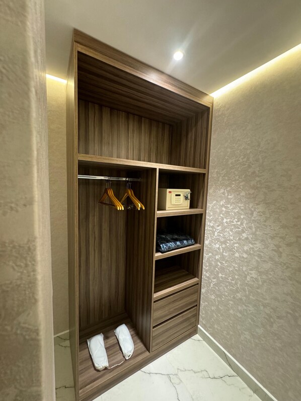 Un vestidor con paneles de madera, estantes y espacio para colgar.