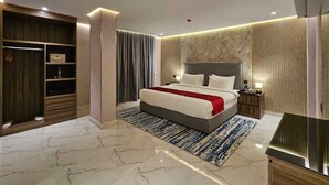 A modern hotel room with a large bed, a walk-in closet, and a marble floor. - Royal Plaza Hotel - Duqm  (Duqm)