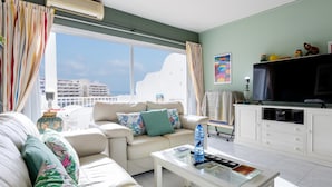 Una sala de estar moderna con un sofá, una mesa de centro y una televisión.