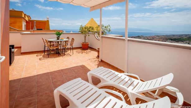 A terrace with a table and chairs, a potted plant, and a view of the sea. - Salt and Sea Apartment, Sea View, Free Wi Fi (Costa Adeje)