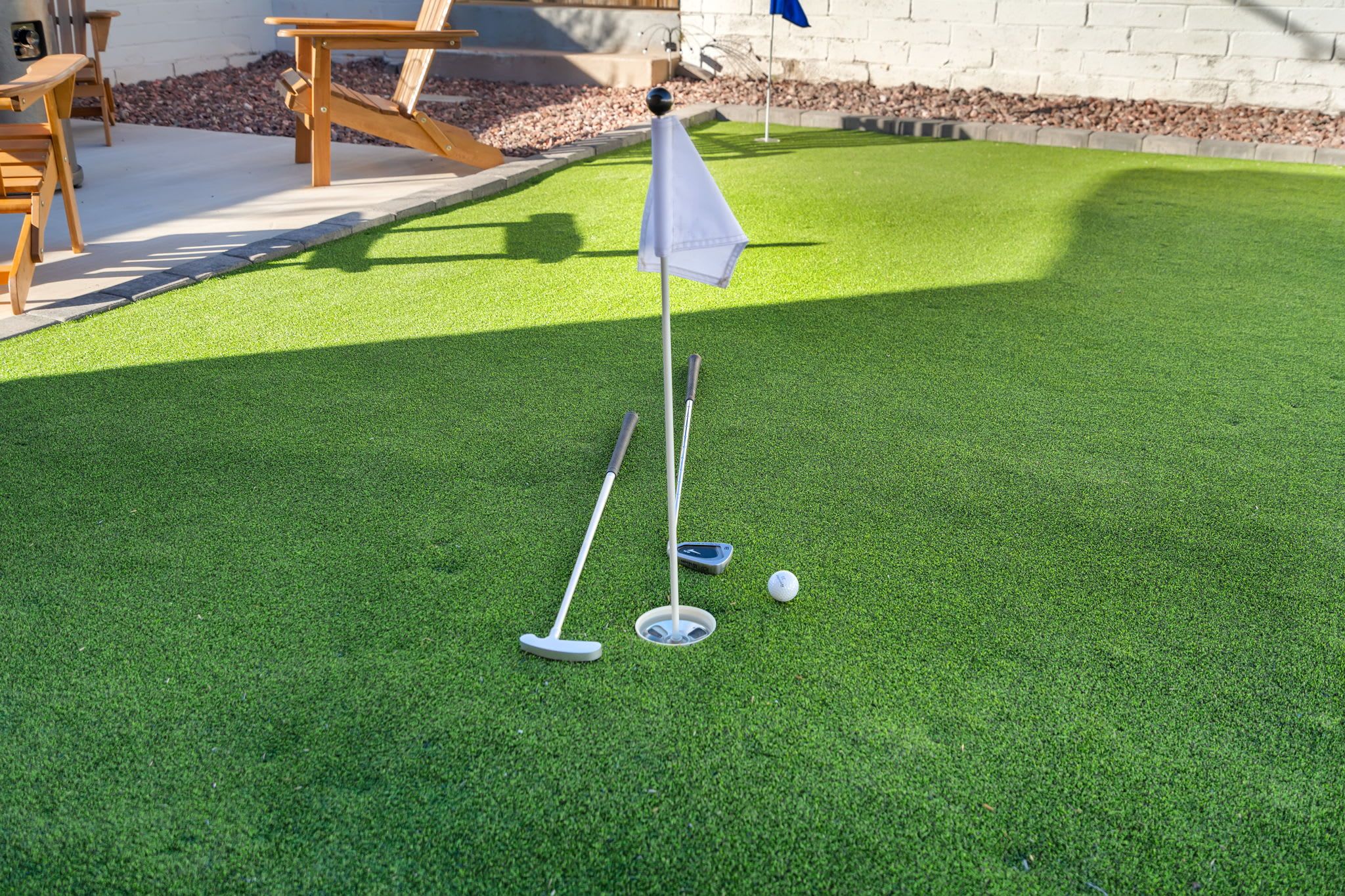 Instalación de minigolf con un putting green, una bandera y pelotas de golf.