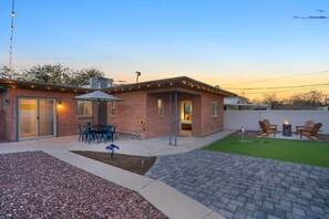 A brick house with a patio, outdoor seating, and a fire pit. - The Swing by Velo (Tucson)