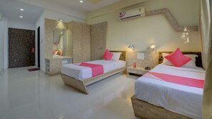 A hotel room with two beds, a large mirror, a wardrobe, and a bathroom with a shower. - Saiba Residency (Paud)