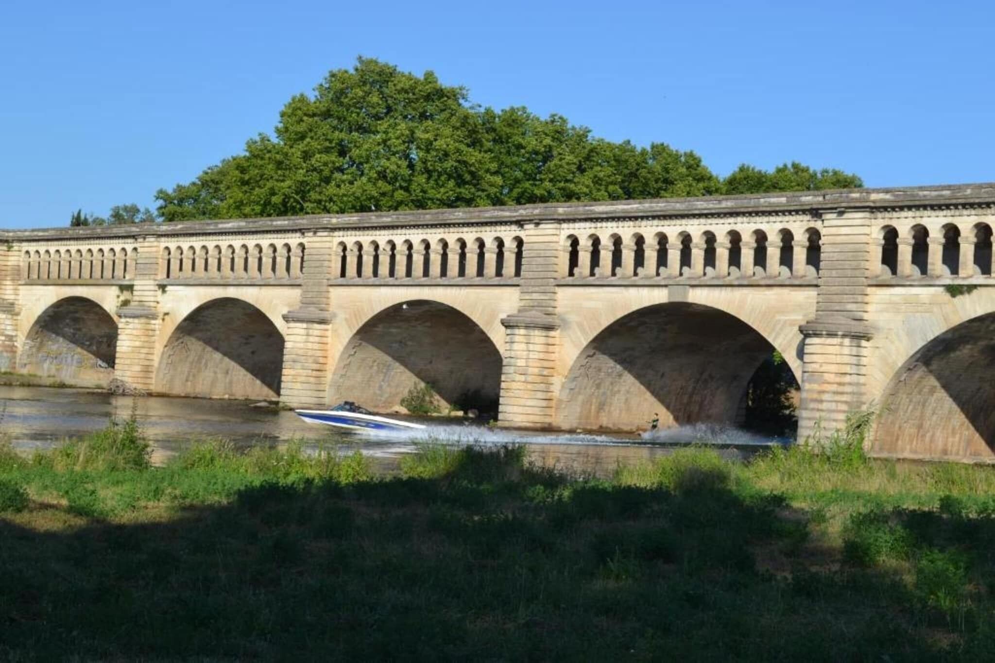 Un puente de piedra con varios arcos sobre un río.