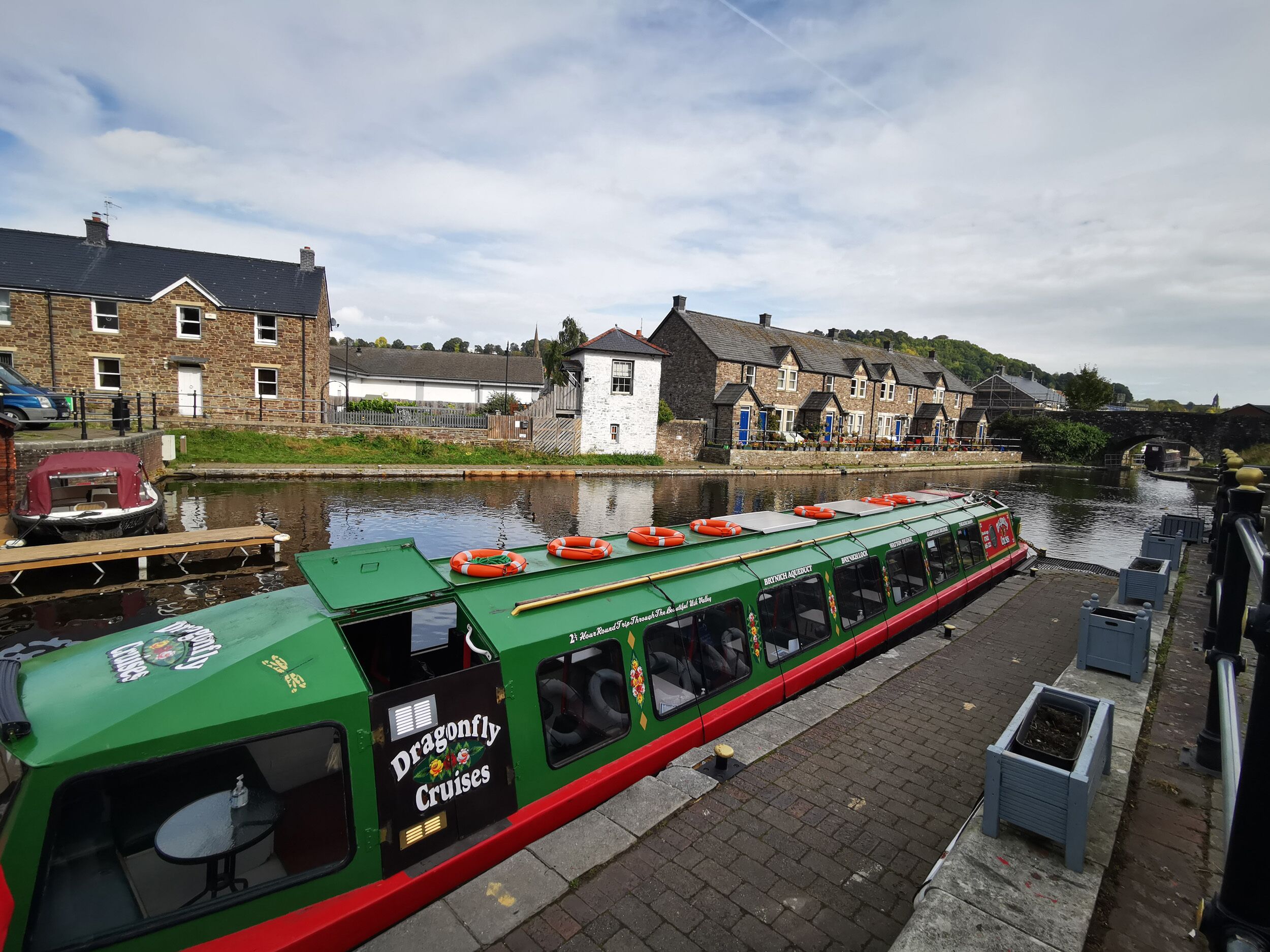 Un bateau vert et rouge, sur lequel on pouvait lire « Dragonfly Cruises », était amarré dans un canal.