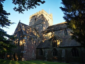 A historic stone building with a prominent tower, arched windows, and a grassy courtyard. - Rhif Deg (Brecon)
