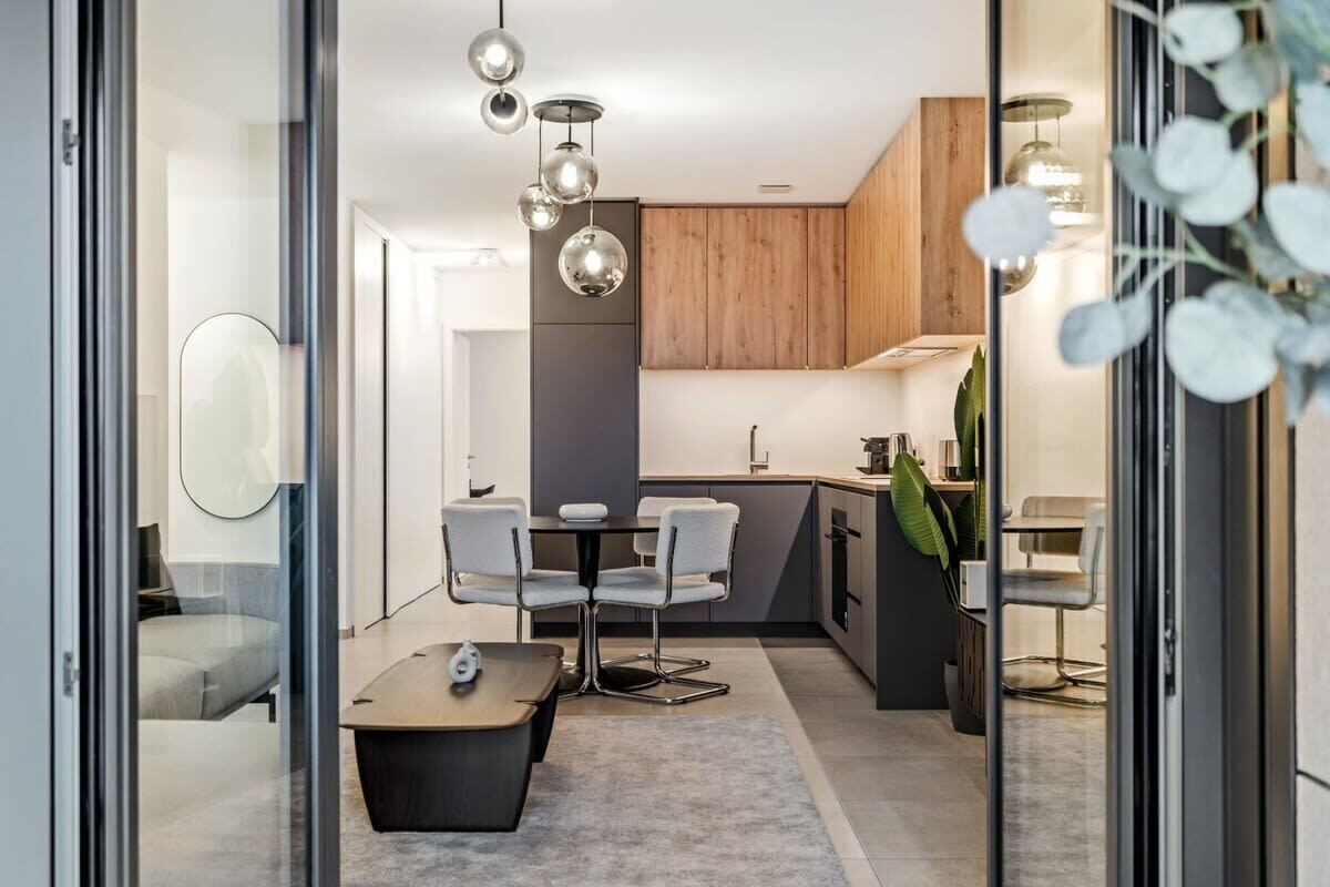 From the balcony, gaze into a living space where natural light and modern amenities blend to create a welcoming urban retreat.