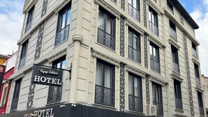 A multi-story hotel with a classic architectural design, featuring ornate window railings and a prominent signboard. - EyüpSultan Palace Hotel (Eyup)
